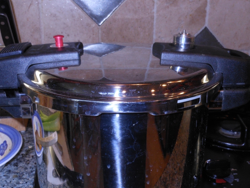 Next, I put the lid on the pressure cooker, turned the heat on high, and brought it to pressure.  See the red button has popped up on the left hand side?  Once it was pressurized, I set the timer for 10 minutes.